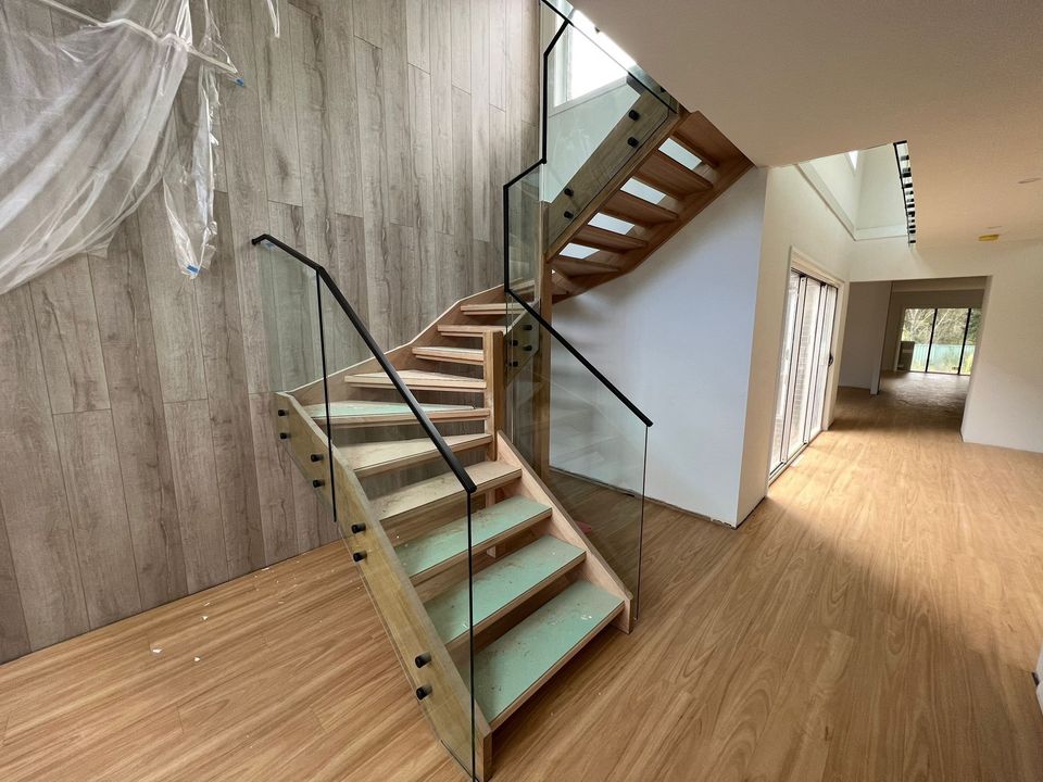 Frameless glass stair balustrade with a matte black handrail