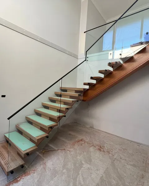 Matte black handrail on a frameless glass stair balustrade