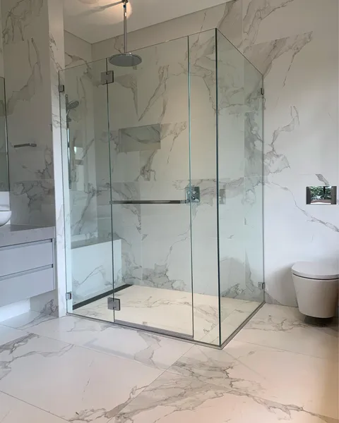 Frameless shower screen in a tiled bathroom