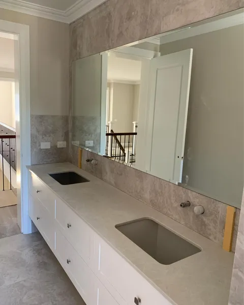 Large custom-cut mirror above a double vanity