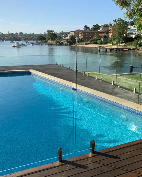 Frameless glass pool fence around a backyard pool
